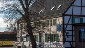 A traditional half-timbered building with a sign indicating it is a hotel and restaurant. - Lindenschänke Hotel garni (Werl)