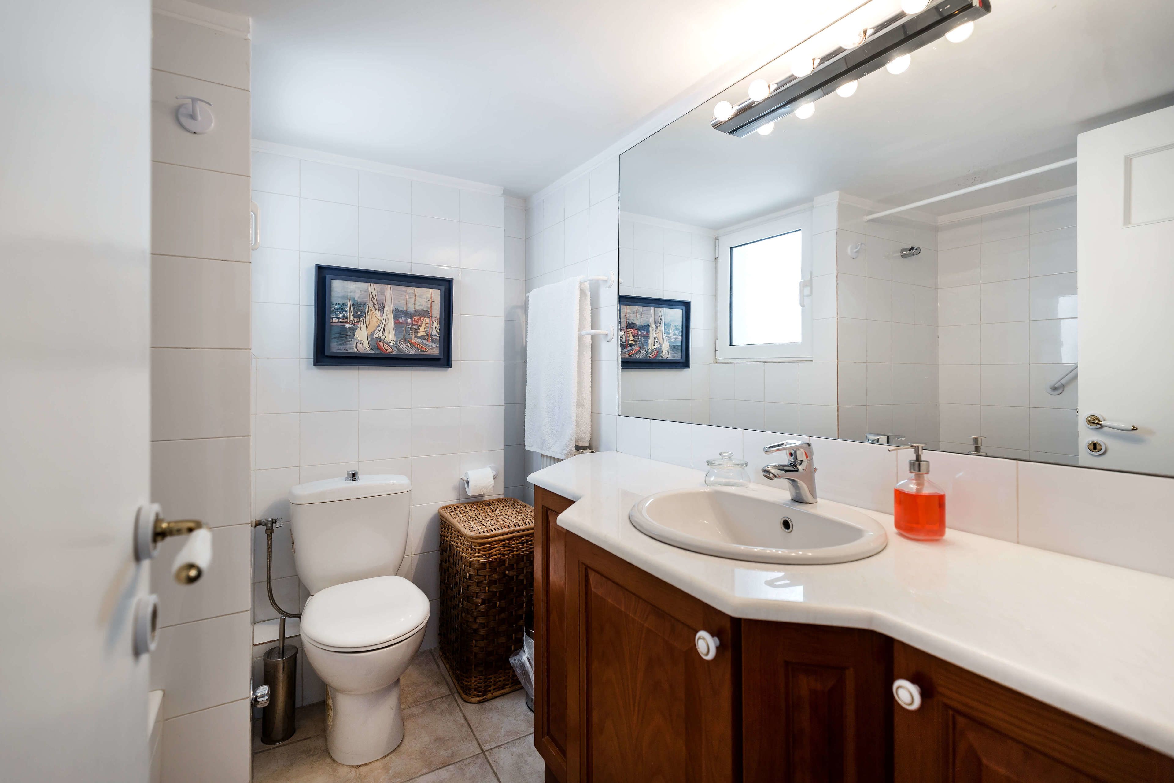 Une salle de bain moderne avec des toilettes, un lavabo et un miroir.