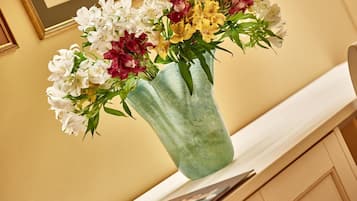 Un vase rempli de fleurs, posé sur une étagère.