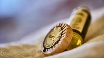 Una botella de vino con corcho y etiqueta sobre un paño blanco.
