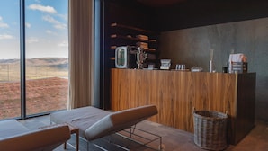 A modern hotel room with a large window, a wooden reception desk, a wicker basket, and a bench. - ROXANICH Winery and Design Hotel (Motovun)