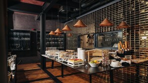 A buffet setup with various food items and a wine rack in a modern kitchen setting. - ROXANICH Winery and Design Hotel (Motovun)