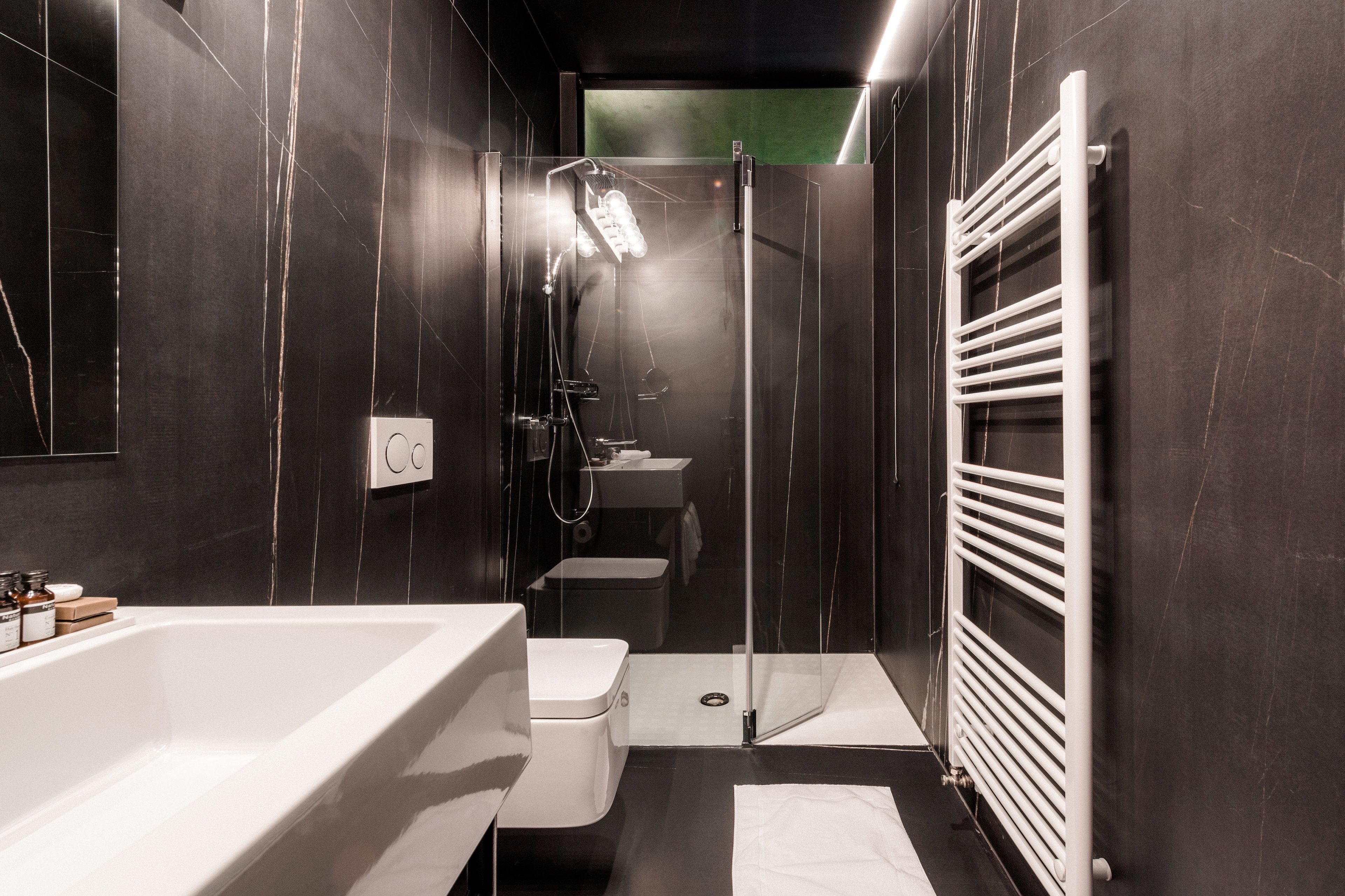 Un baño moderno con bañera, inodoro y zona de ducha.
