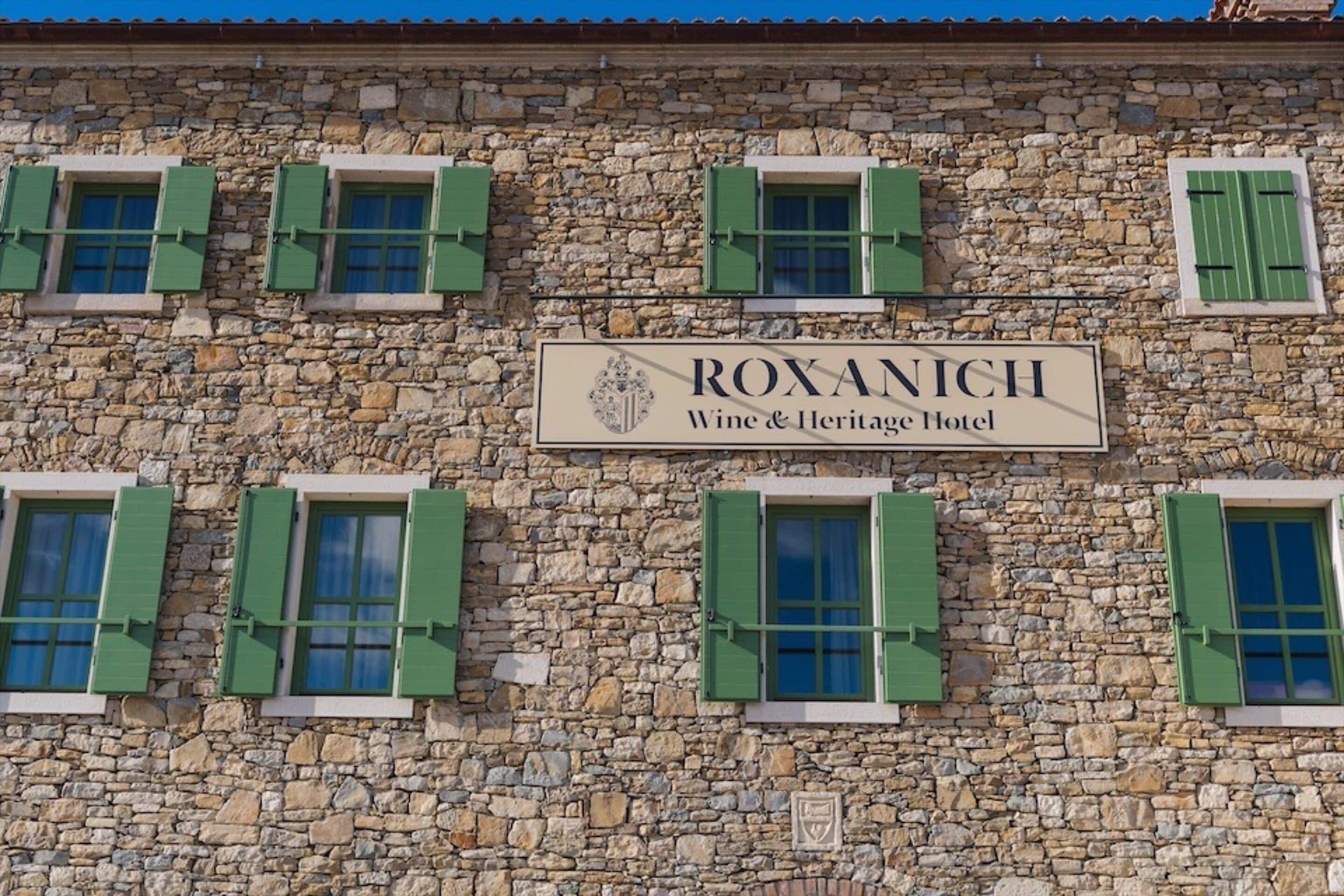 A stone building with a sign that reads "ROXANICH Wine & Heritage Hotel".