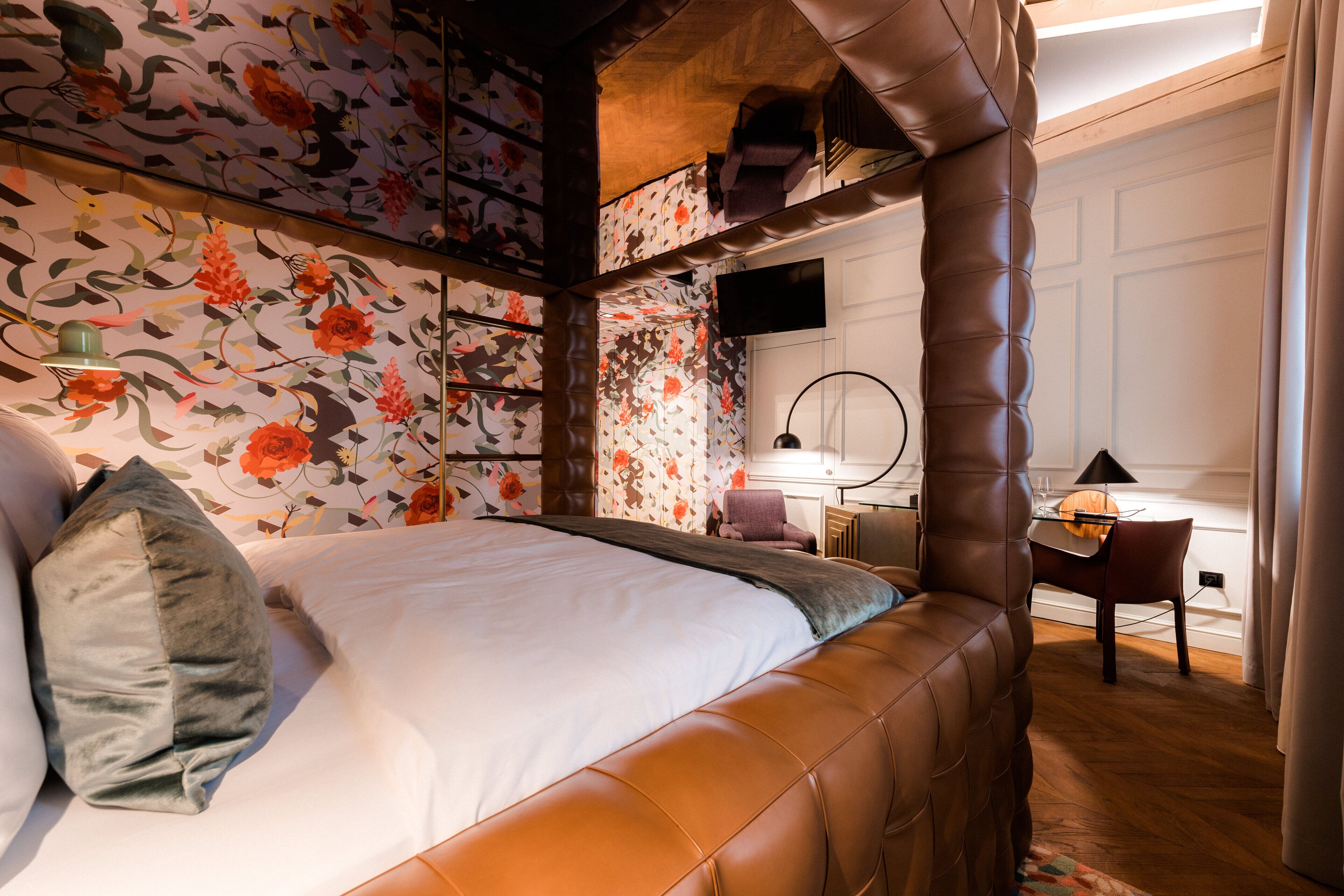 A bedroom with a large bed, a desk, and a chair.