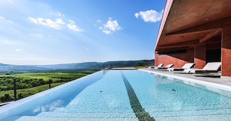 Una piscina al aire libre de temporada, sillones reclinables de piscina