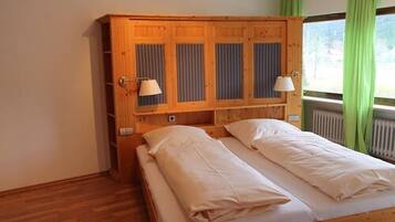 Una cama individual con cabecera de madera y dos lámparas de noche.
