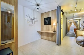 Un pasillo de hotel con paneles de madera, un mostrador de recepción y obras de arte en las paredes.