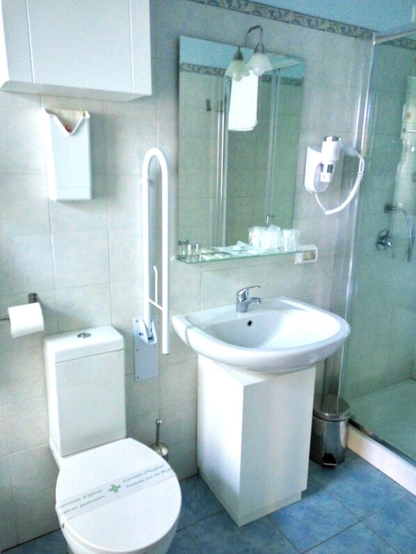 Un baño con inodoro, lavamanos y ducha.