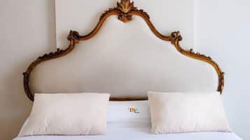 A bed with a wooden headboard and two pillows.