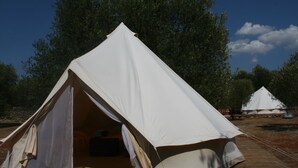 A large, white tent with a pitched roof, set on a wooden deck. - Accampamento Rurale Macaria (Alliste)