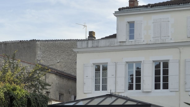 A house with a conservatory, outdoor seating, and a garden. - Chambres d'hôtes H De Surgeres (Surgeres)