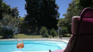 Een seizoensgebonden buitenzwembad en parasols bij het zwembad