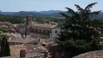 A historic town with a prominent church featuring a bell tower, surrounded by traditional buildings and lush greenery.