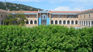 A building with a central courtyard, arched windows, and a blue entrance. - Hotel Regina (Sète)