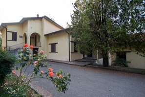 A two-story building with a beige facade, a balcony, and a tree in front. - Antico Colle Toscano Resort (Arcidosso)