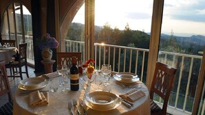 Une table à manger dressée pour quatre personnes, avec vue sur les montagnes.
