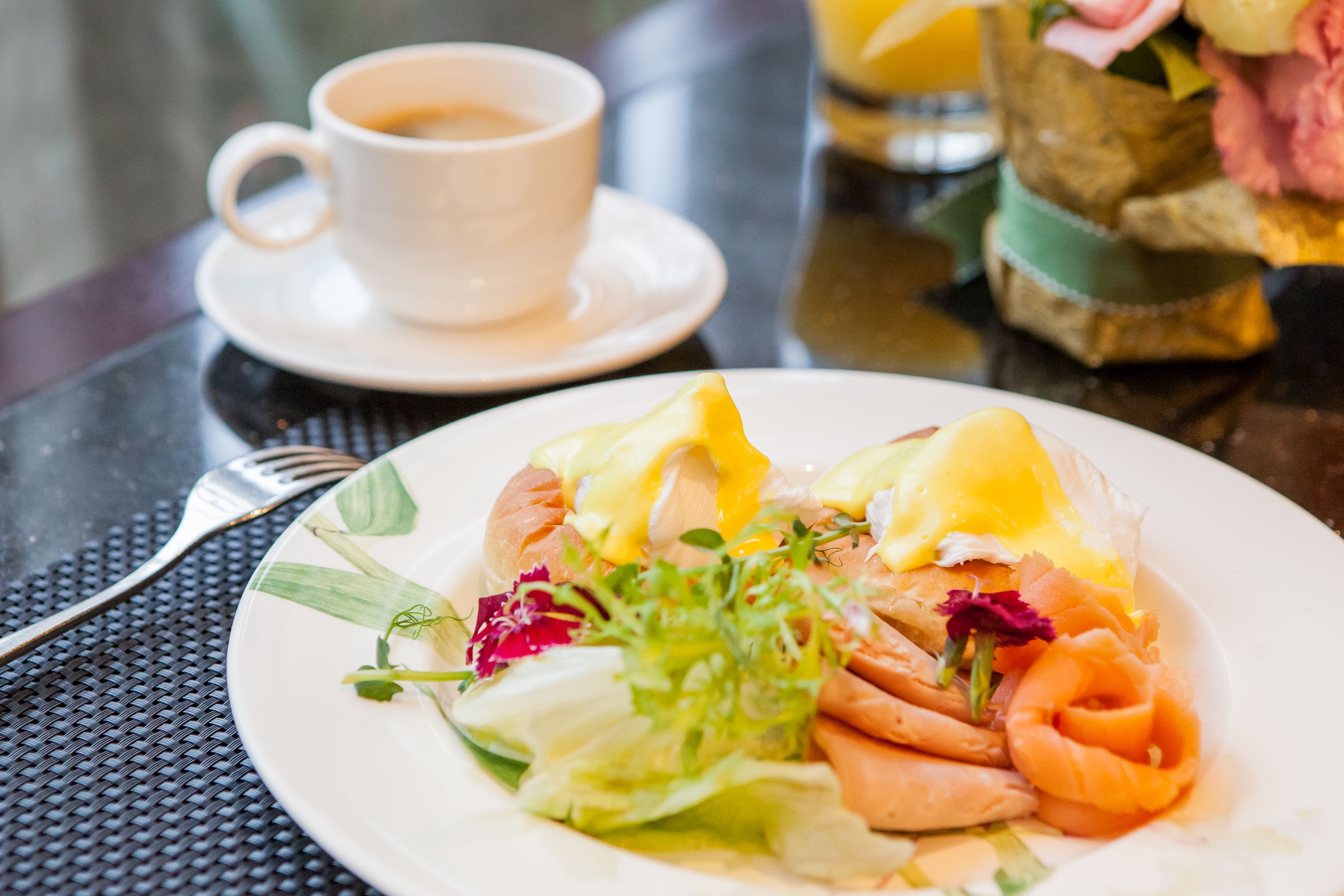 A plate of food with a cup of coffee on a table.