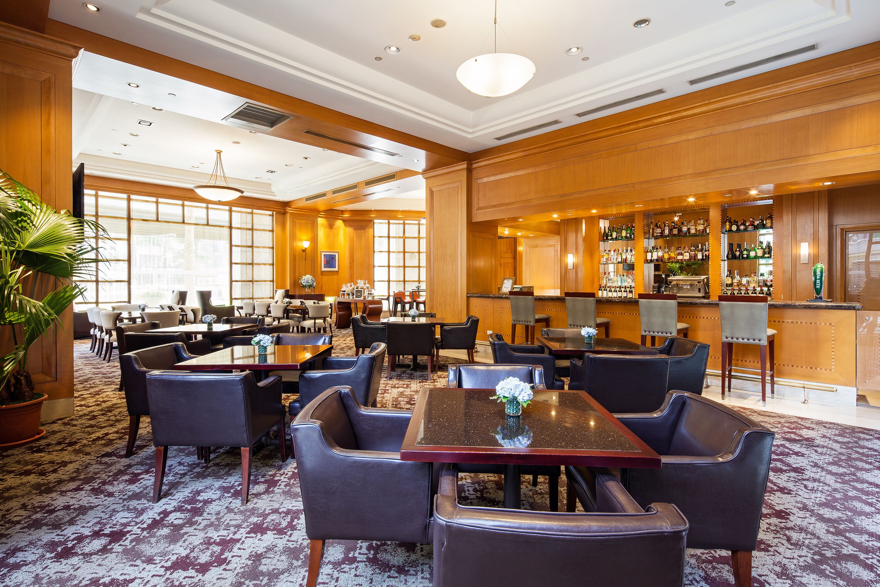 Een hotel lobby met verschillende zithoeken, een bar en een receptiebalie.