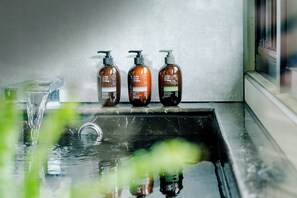 Three bottles of shampoo on a bathroom counter next to a sink. - RSL Hotel Taipei Zhonghe (New Taipei City)