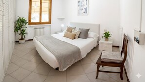 A bedroom with a bed, bedside tables, a chair, a window, and a radiator. - Casa Airenti (Imperia)