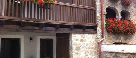 A traditional stone building with a wooden balcony and flower boxes.