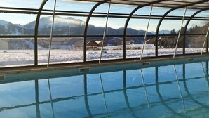An indoor swimming pool with a view of snowy mountains through large windows. - Les Cimes du Léman (Habere-Poche)