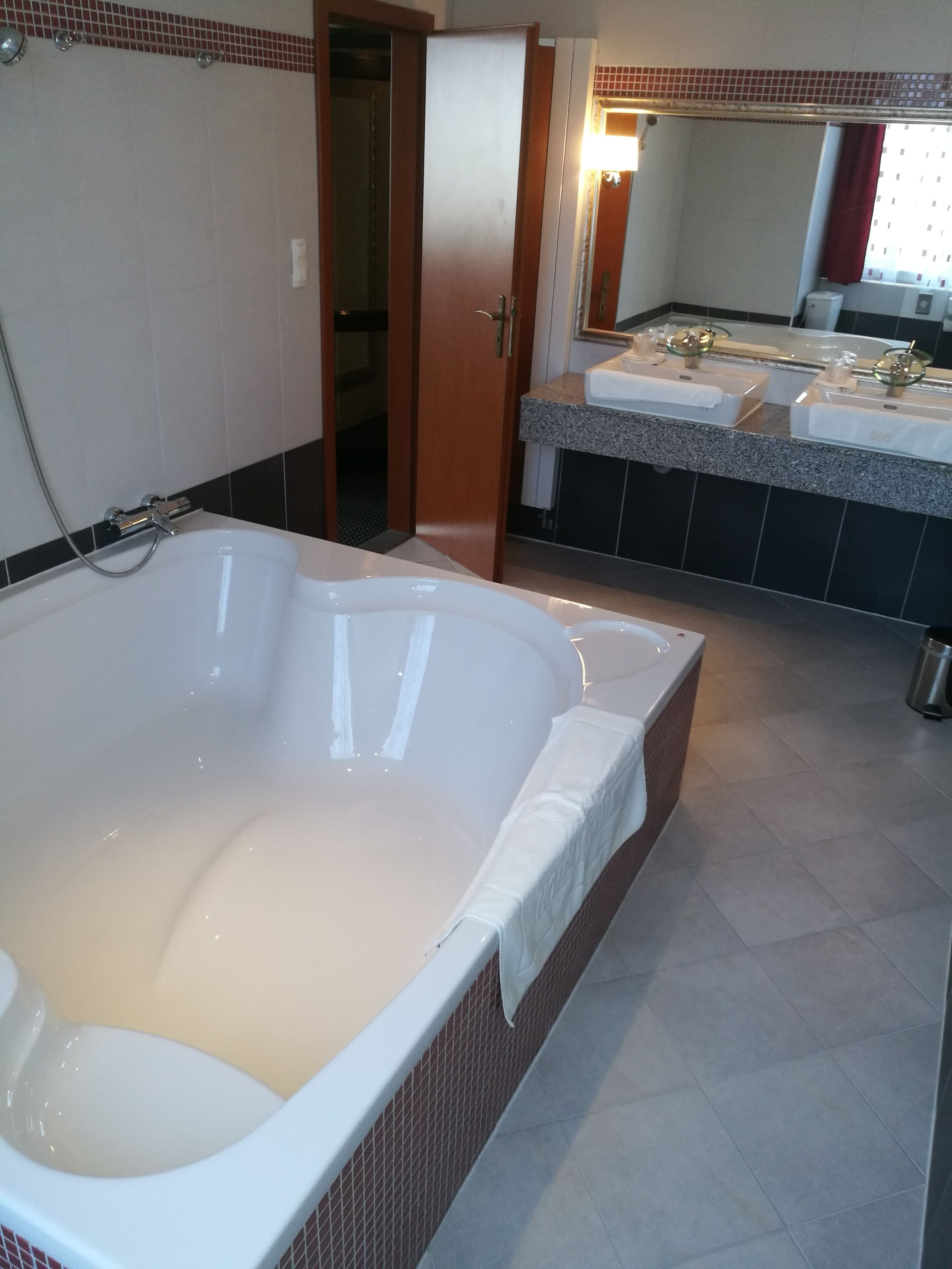 A bathroom with a large bathtub, a separate shower area, and a vanity with a mirror.