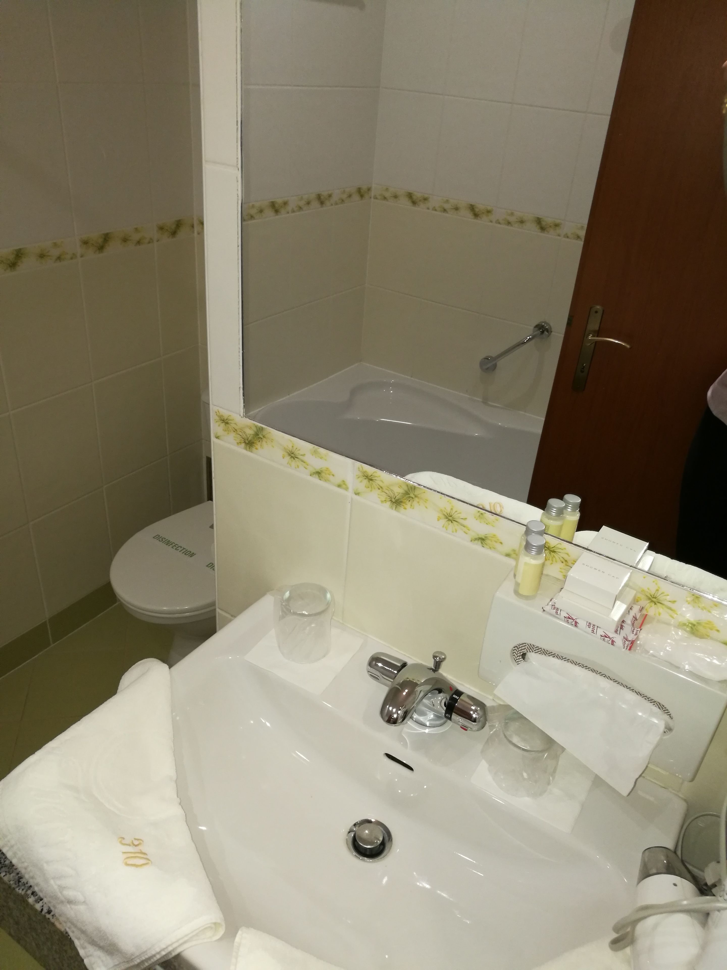 Un baño con lavamanos blanco, un espejo, inodoro y bañera.