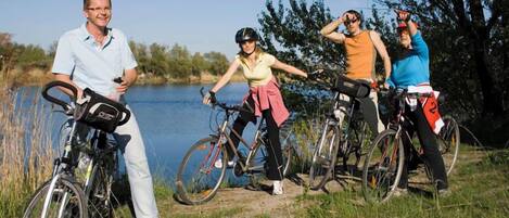 Un grupo de personas con bicicletas cerca del agua.