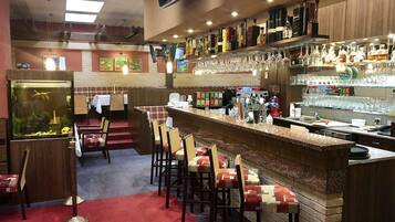 Zona de bar con mostrador, taburetes y un acuario.