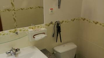 Un baño con lavamanos blanco, espejo, inodoro y ducha.