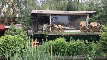 A floating restaurant with outdoor seating and Coca-Cola branding.