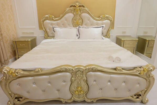 A large bed with ornate gold detailing and tufted headboard, flanked by matching nightstands. - Hiso Potato Resort (Wang Noi)