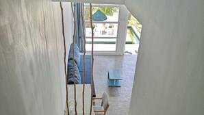 A staircase leading to a balcony with a view of outdoor furniture and a hanging light fixture. - Banana Garden Mirissa (Mirissa)
