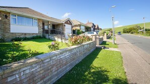 A residential street with houses, a clear sky, and a road. - Dean Court Garden Parking by Brighton Holiday Lets (Brighton)