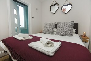 A bedroom with a bed, two heart-shaped mirrors, and a door. - Brighton Abode by Brighton Holiday Lets (Brighton)