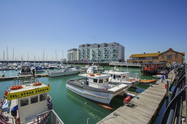 A marina with several boats docked, a pier, and a building labeled "The West Quay".
