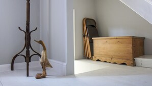 Een trap met een houten dressoir en een houten beeldhouwwerk op de vloer.