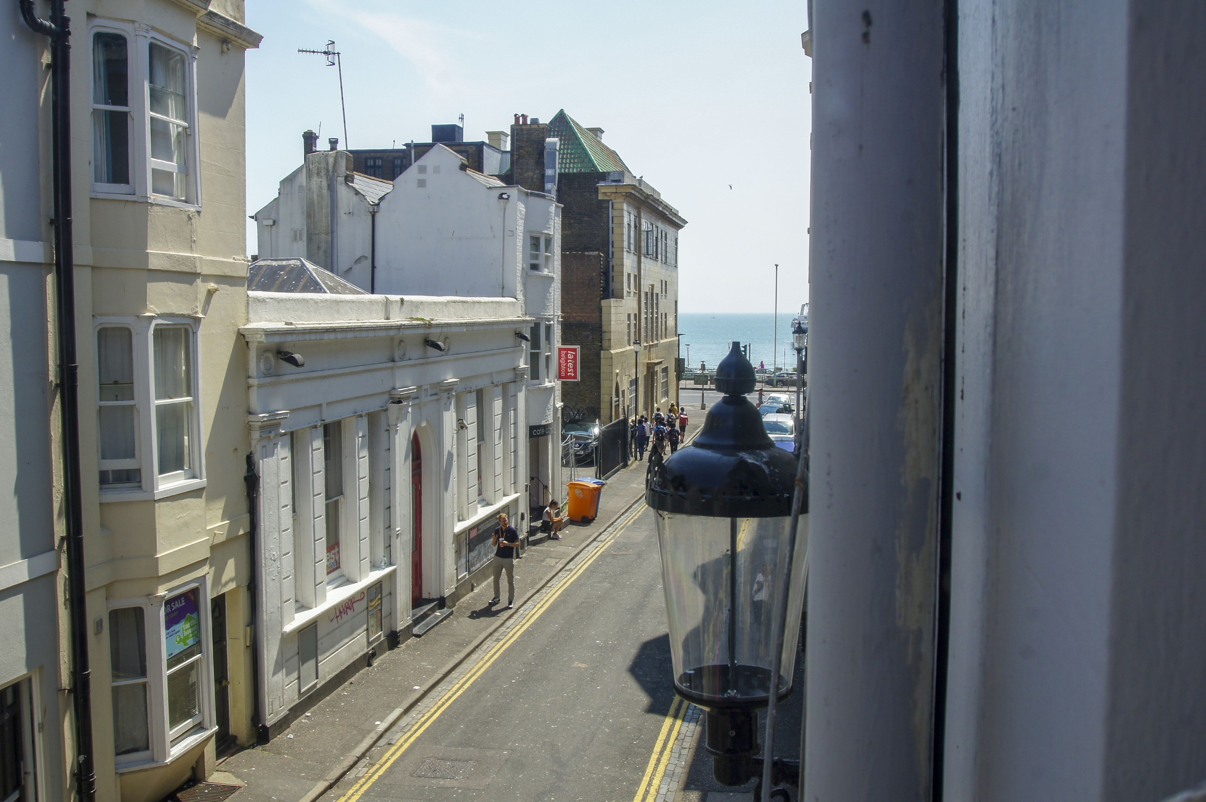 A street view with buildings, a lamp post, and a clear sky.