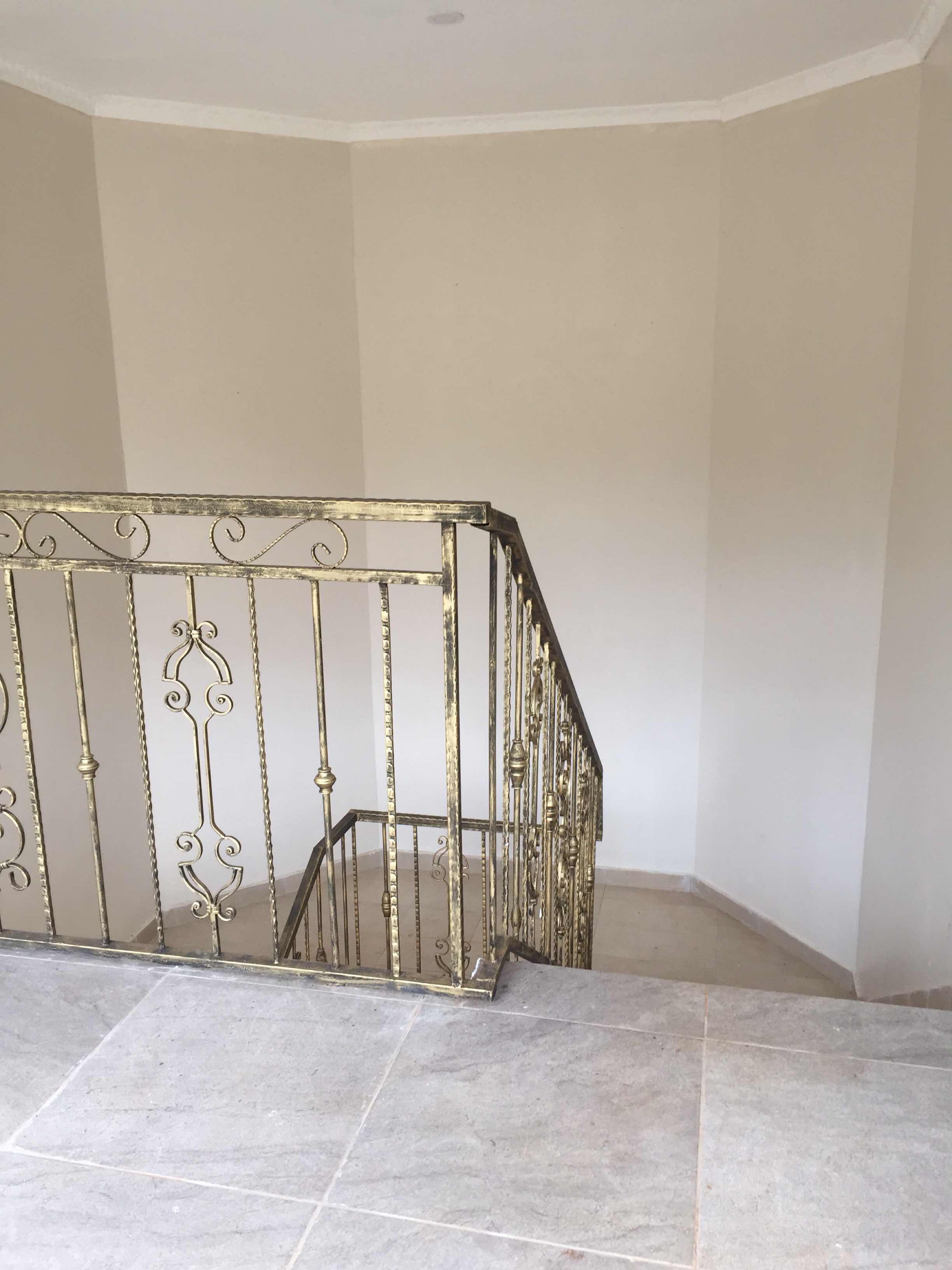 A staircase with a metal railing and tiled floor.