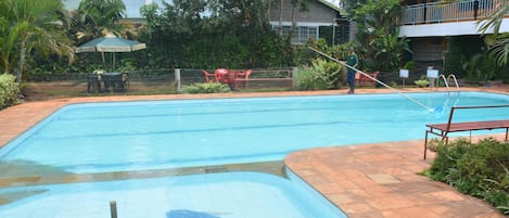 Una piscina al aire libre, sombrillas