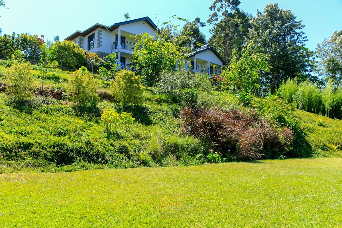 Uma casa com um jardim amplo e um gramado bem cuidado.