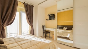 A bedroom with a bed, a desk, and a chair.