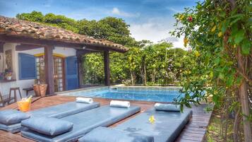 Uma área de piscina com espreguiçadeiras e um pérgola.