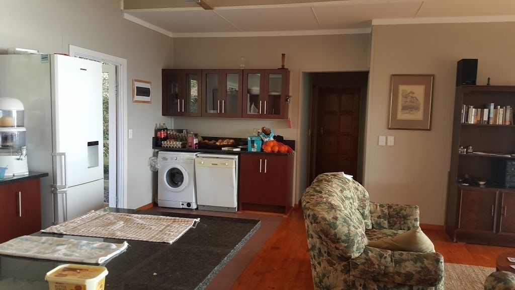 Een ruimtelijke woonkamer met een keuken, een wasmachine, een eethoek en een zithoek.