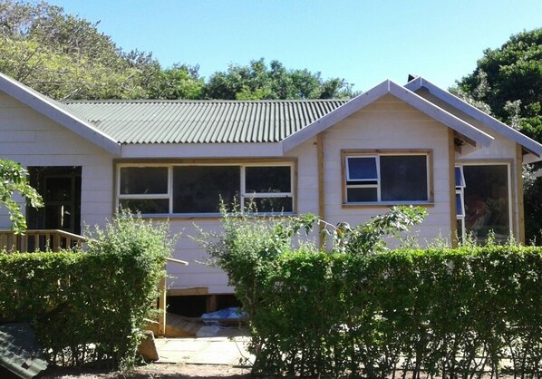 A two-story house with a gabled roof, large windows, and a visible garage door. - Dream Beach Self Catering Lodge (Ponta d'Ouro)