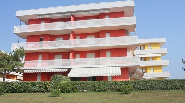 A multi-story building with balconies and a flat roof.