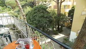 A balcony with a table set for two, featuring a newspaper, a cup, and a glass of red beverage. - Hotel Arco del Sole (Lavagna)