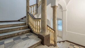 Un magnifique escalier en marbre, avec des marches et des balustrades, menant à l’étage supérieur.